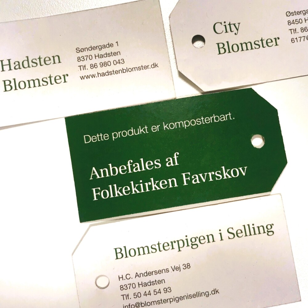 Manilamærket, som også er komposterbart, viser på den grønne forside, at buketten/dekorationen er kan komposteres. På bagsiden er der plads til de tilmeldte blomsterhandleres adresse og kontaktoplysninger.
